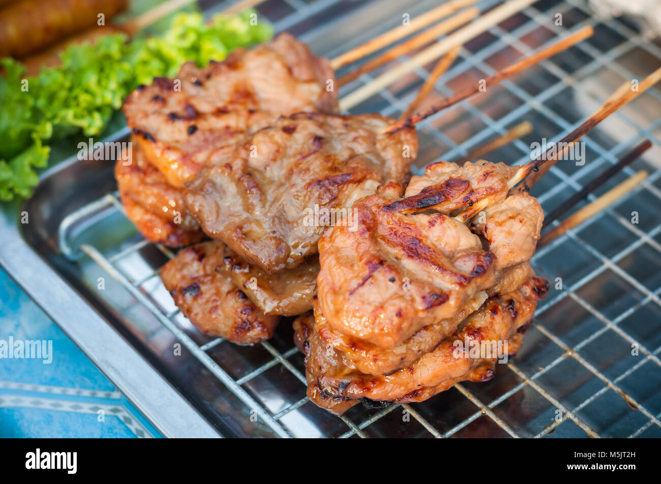 Premium Photo  Closeup of grilled skewered milk pork on stick thai street  food market