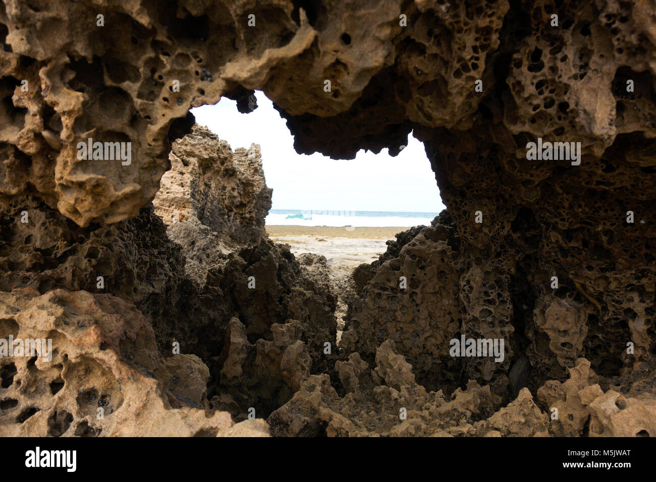 Through the rocks. Australian Beach Stock Photo - Alamy