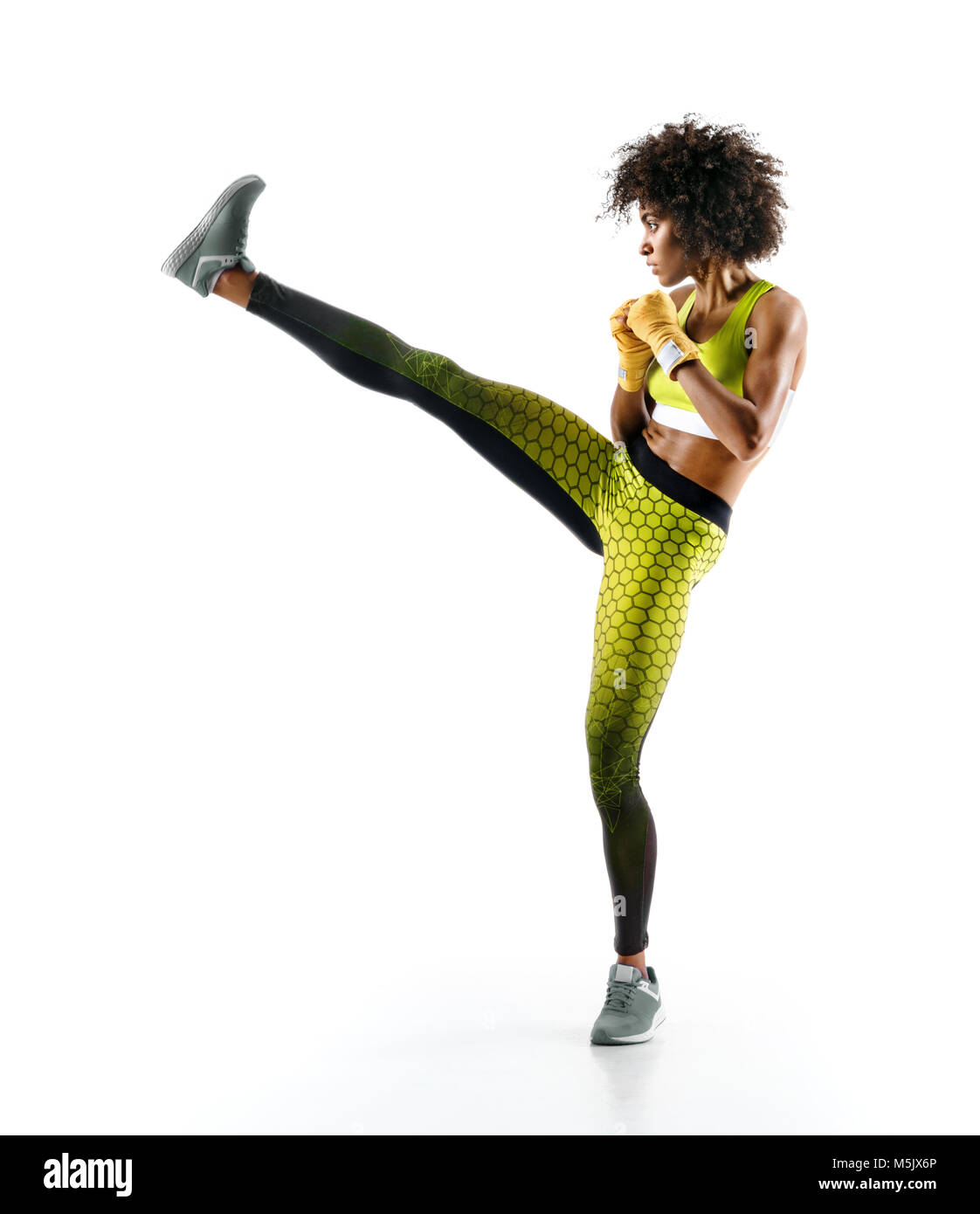 Girl practicing tae-bo exercises, kicking forward with legs. Photo of sporty african girl on white background Stock Photo