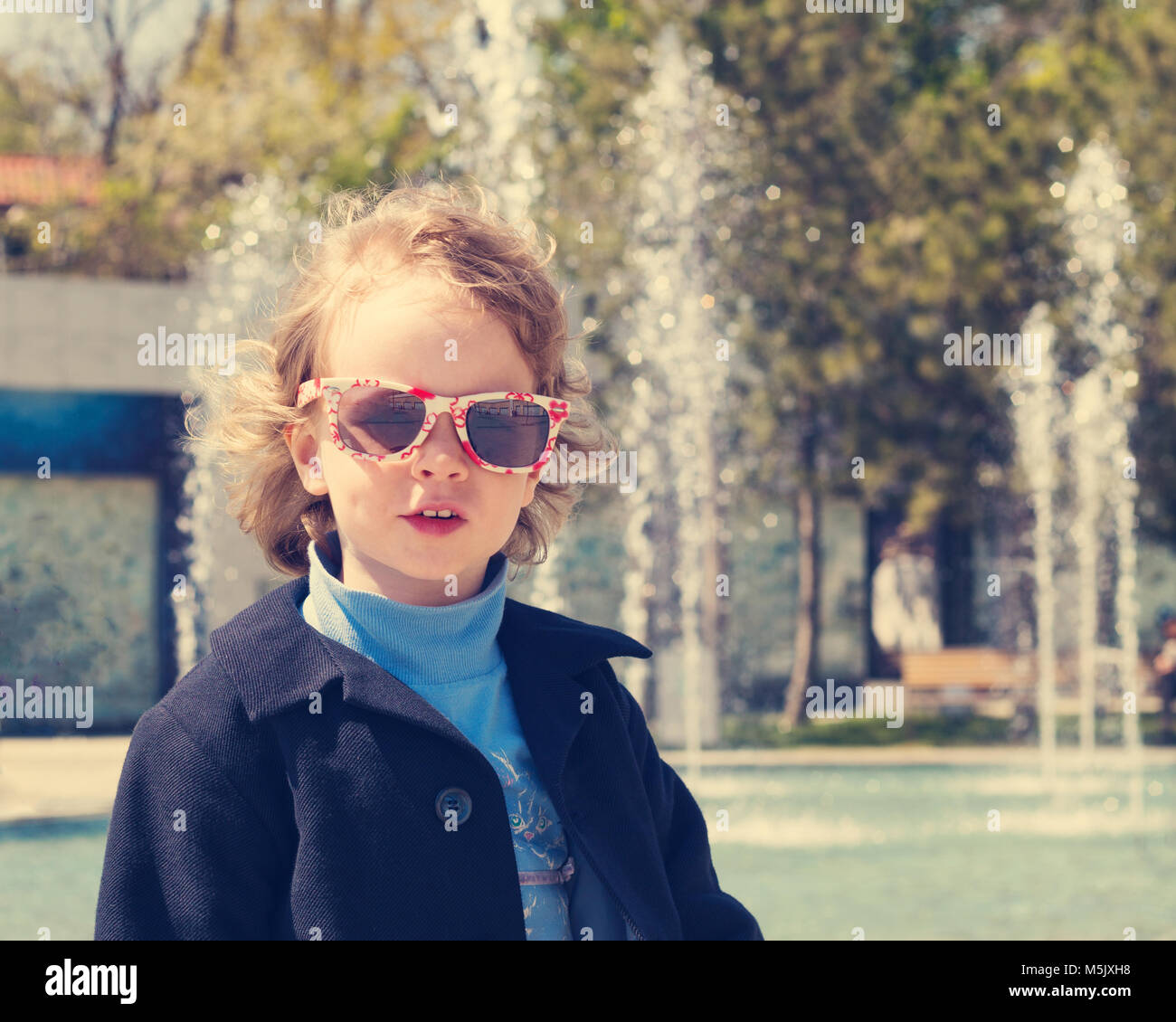Beautiful little girl in sunglasses. The image is tinted. Stock Photo
