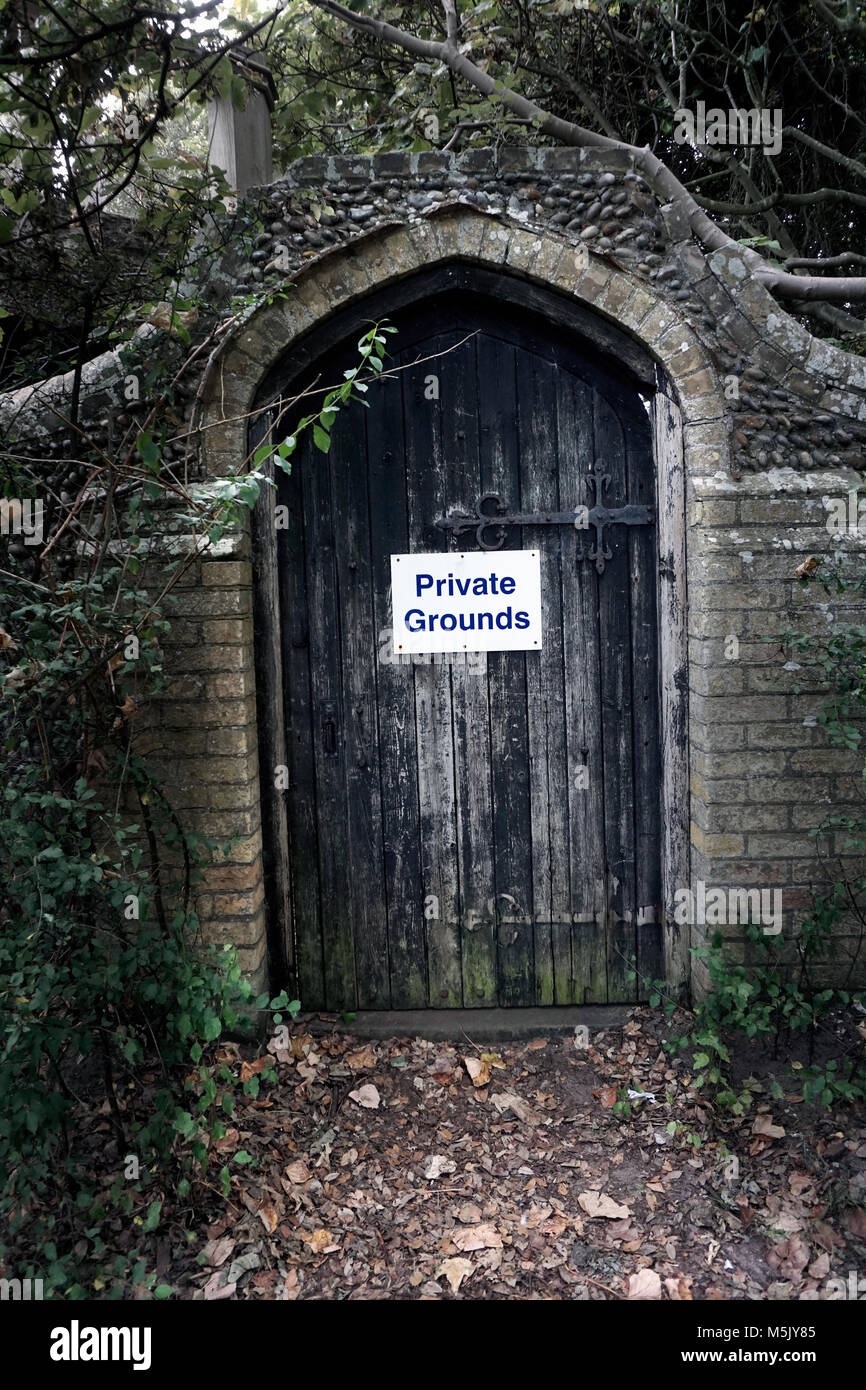 wooden door in old wall into private grounds Stock Photo