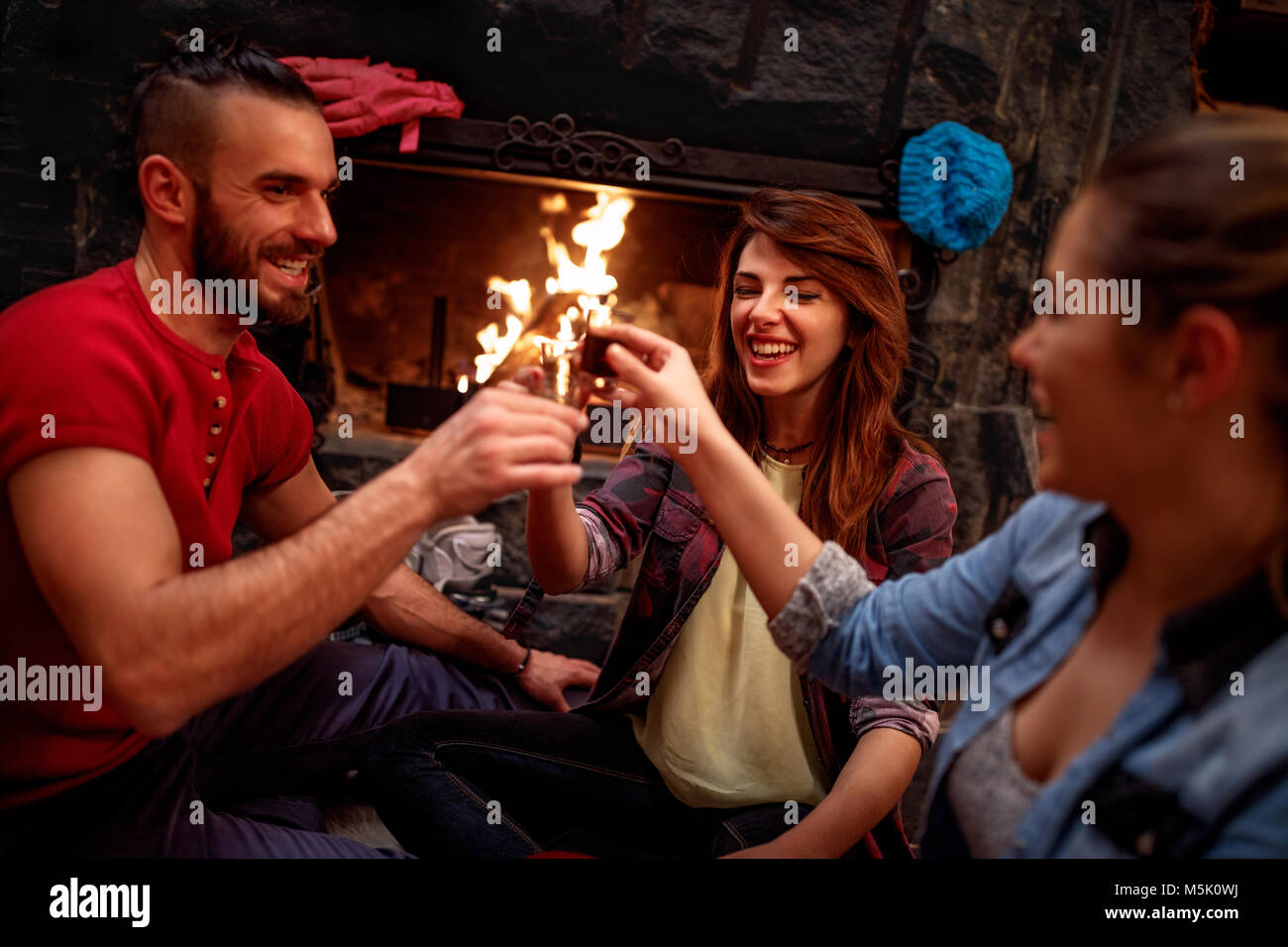 Group of smiling friends cheering with drinks after skiing day Stock Photo