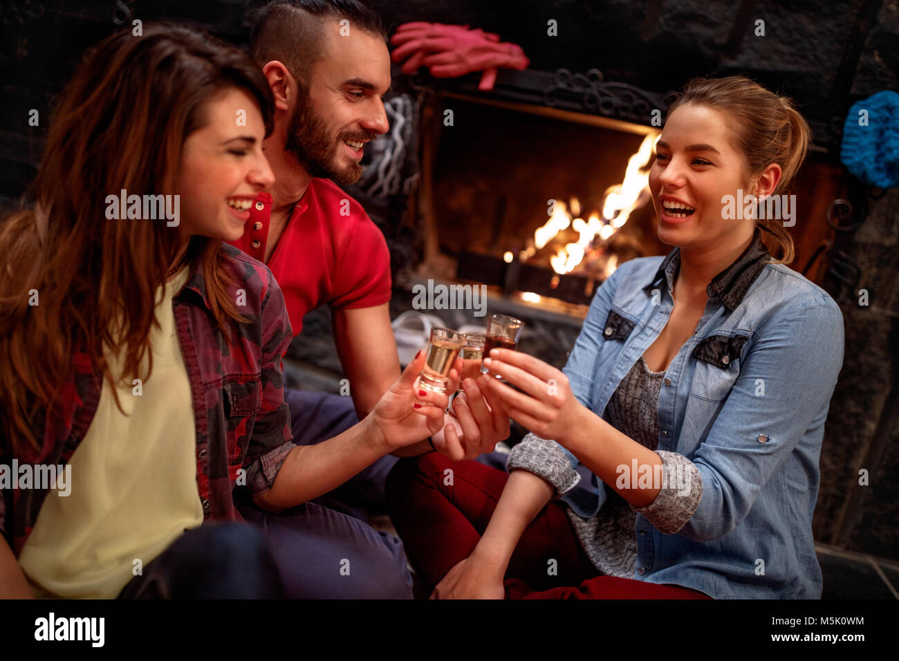 Time of relaxing after skiing-Smiling friends cheering with drinks together Stock Photo