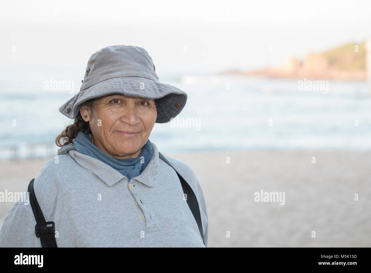 Older Smiling & Friendly Mexican Woman Working on a Resort Beach Raking ...
