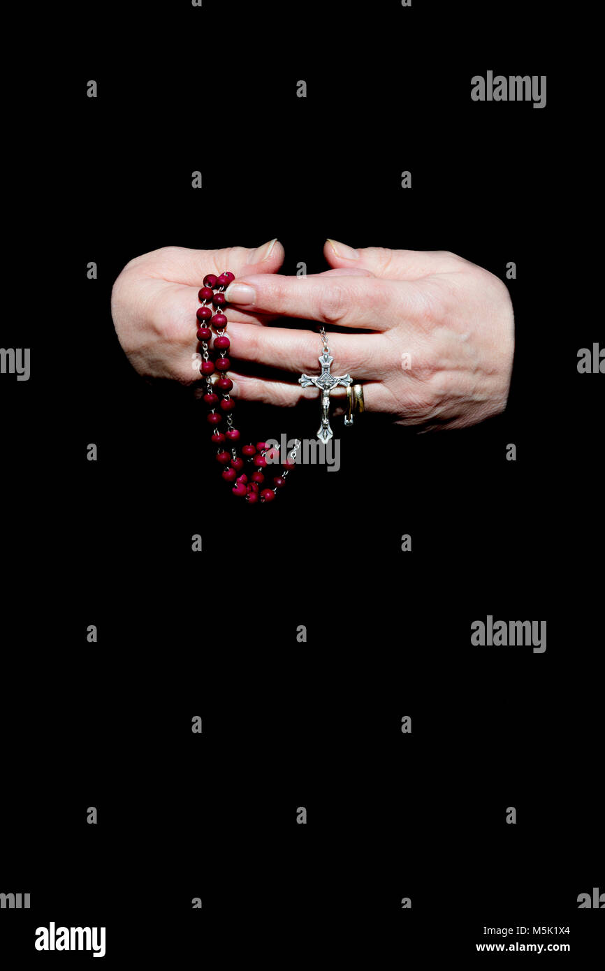 Female Hands Holding Rosary Beads.  Isolated on Black Stock Photo