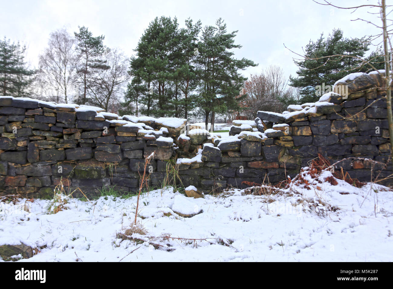 Collapsed dyke wall covered in snow in countryside Stock Photo