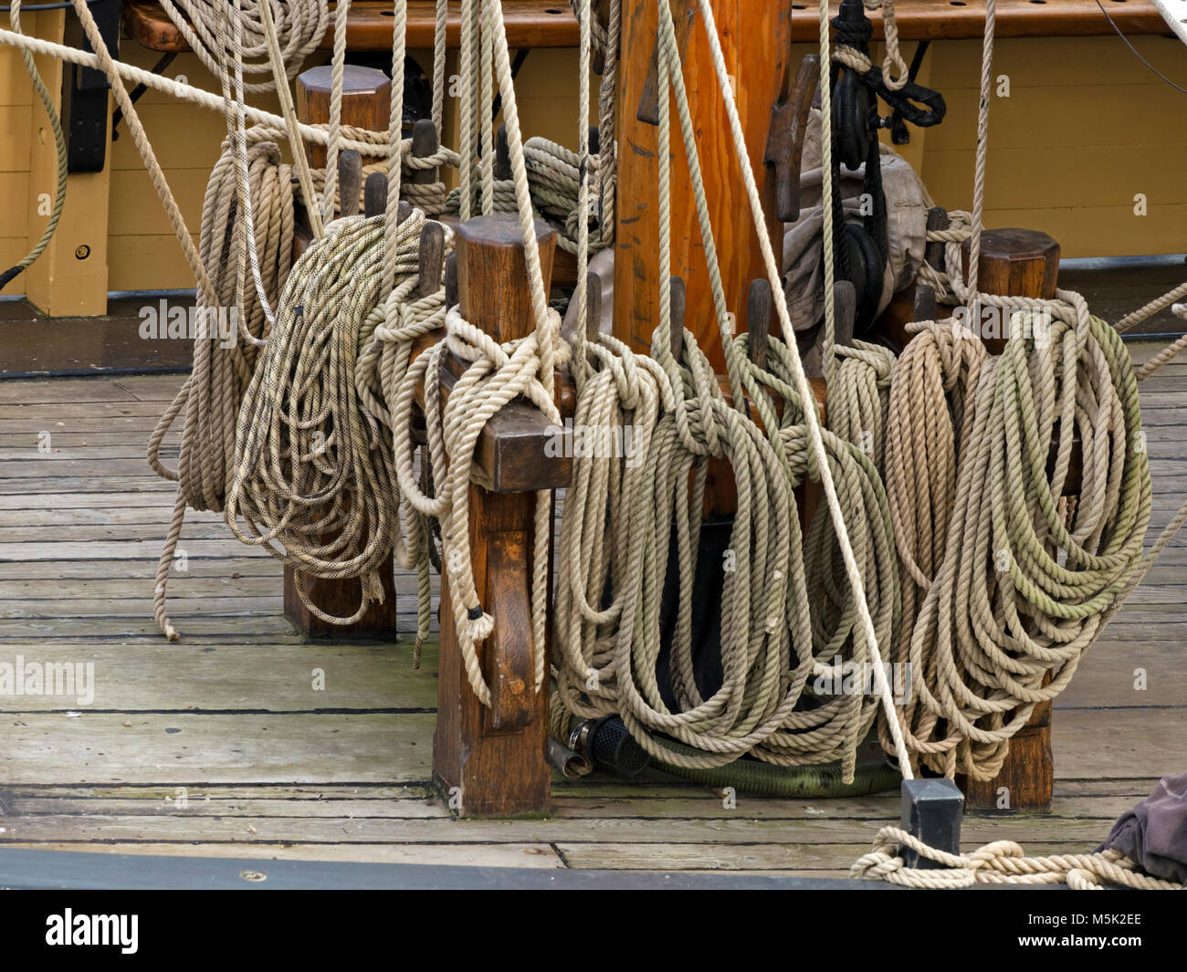 Detail of coiled stored ropes from rigging on deck of tall-ship Phoenix in Charlestown Harbour, Cornwall, England, UK Stock Photo