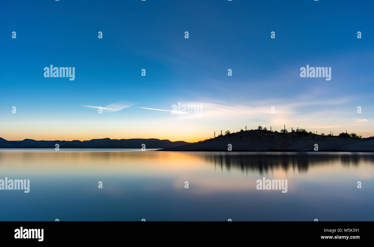 Sunrise at Lake Pleasant in Peoria Arizona. I was out hiking and captured this long exposure of this beautiful mountain casting a shadow over the lake. Stock Photo