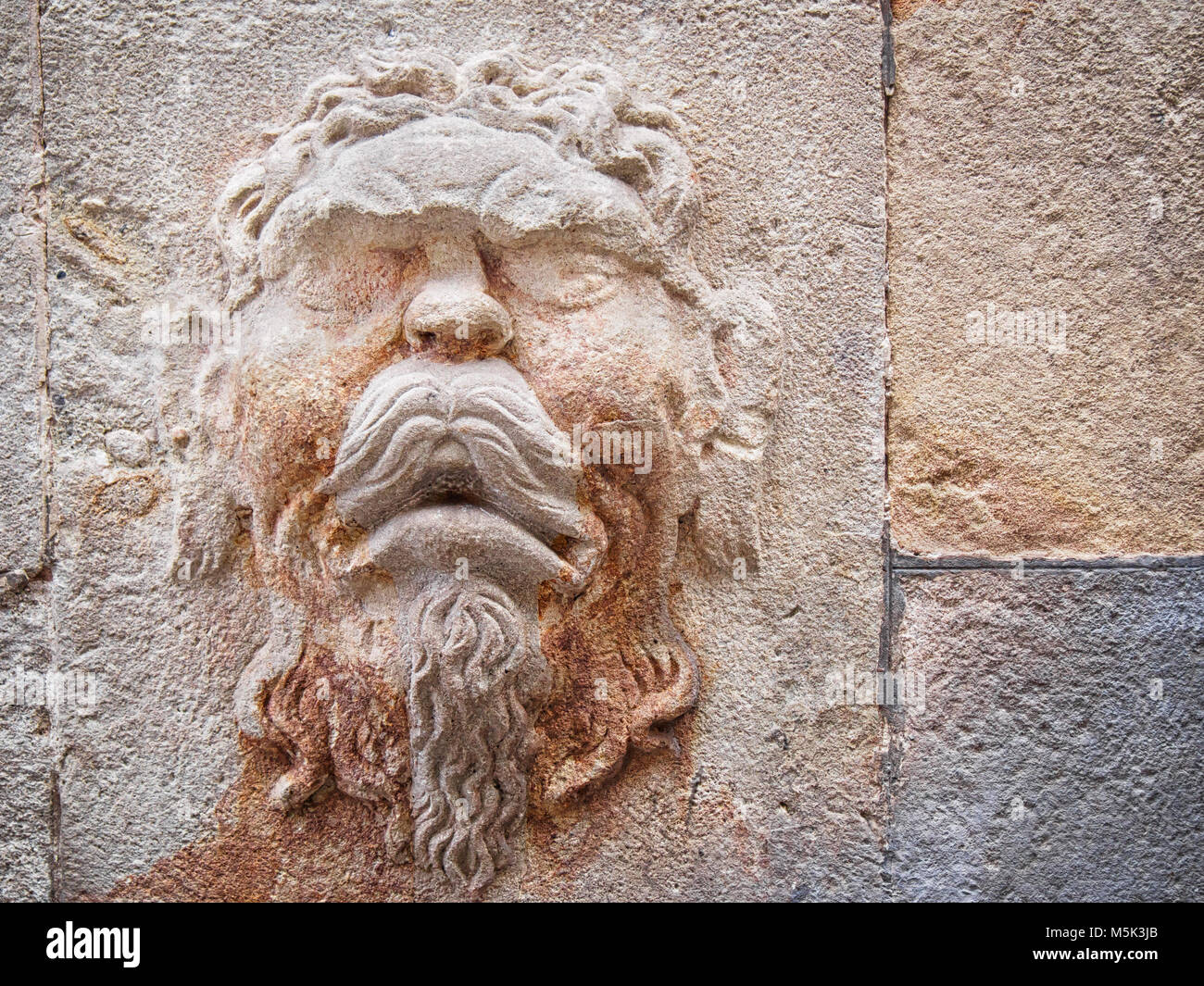 Bas-relief on ta wall of the face of an antique Greek god Stock Photo