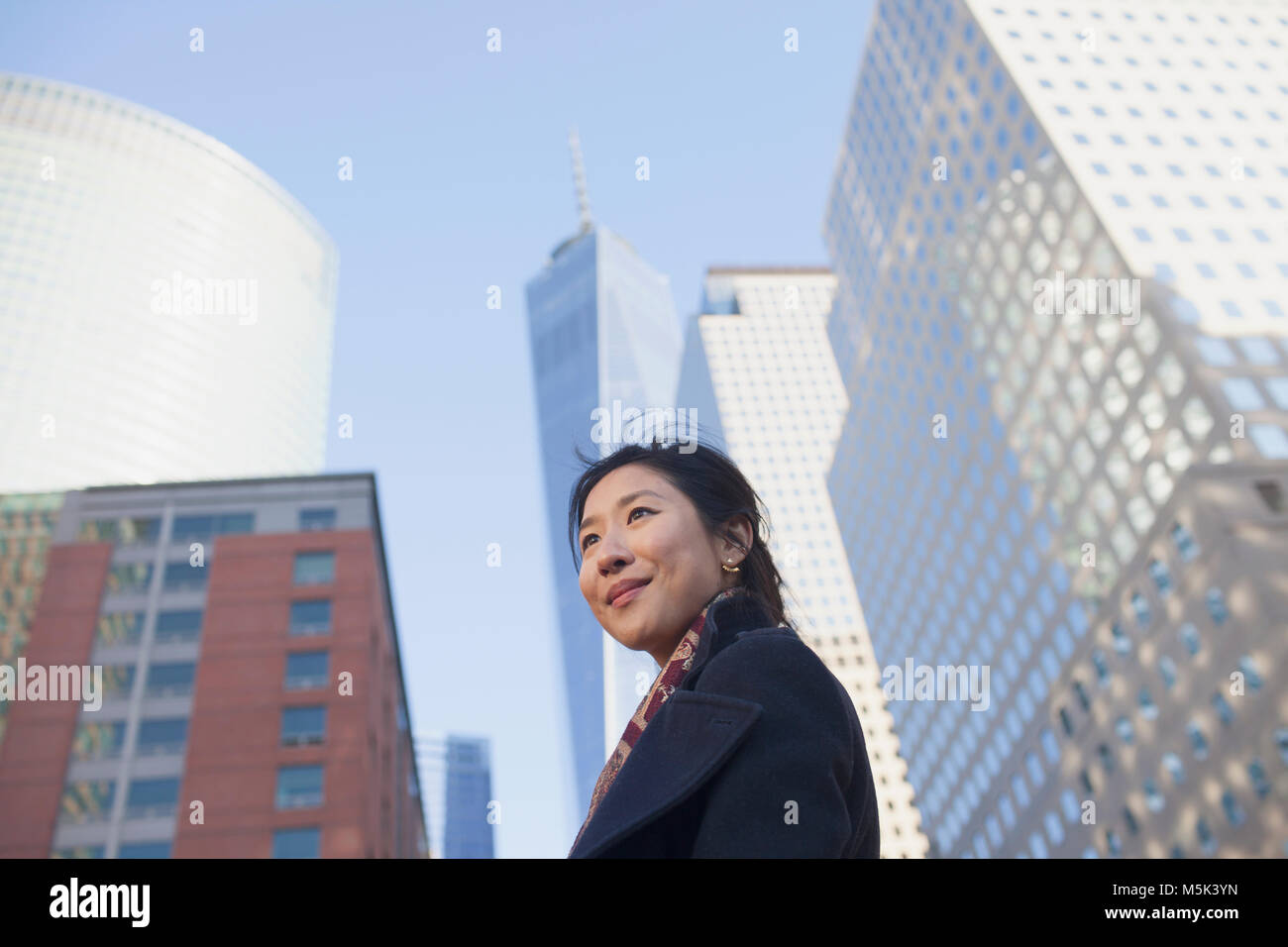 Young asian business woman looking up at skyline of big city Stock ...