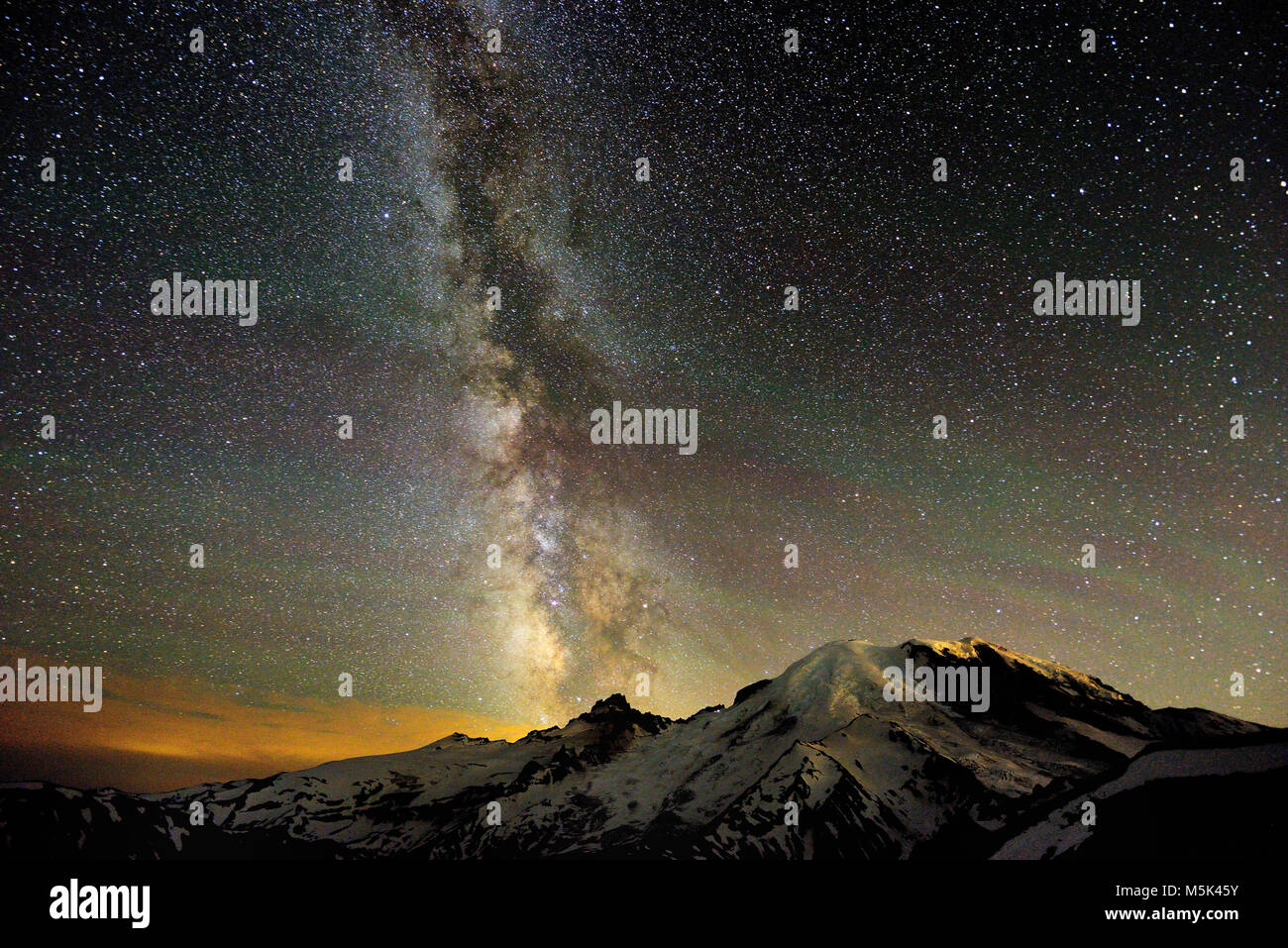 The Milky Way rises above the summit of Little Tahoma, as Mount Rainier--also known as Mount Tahoma--rises to the west. Stock Photo