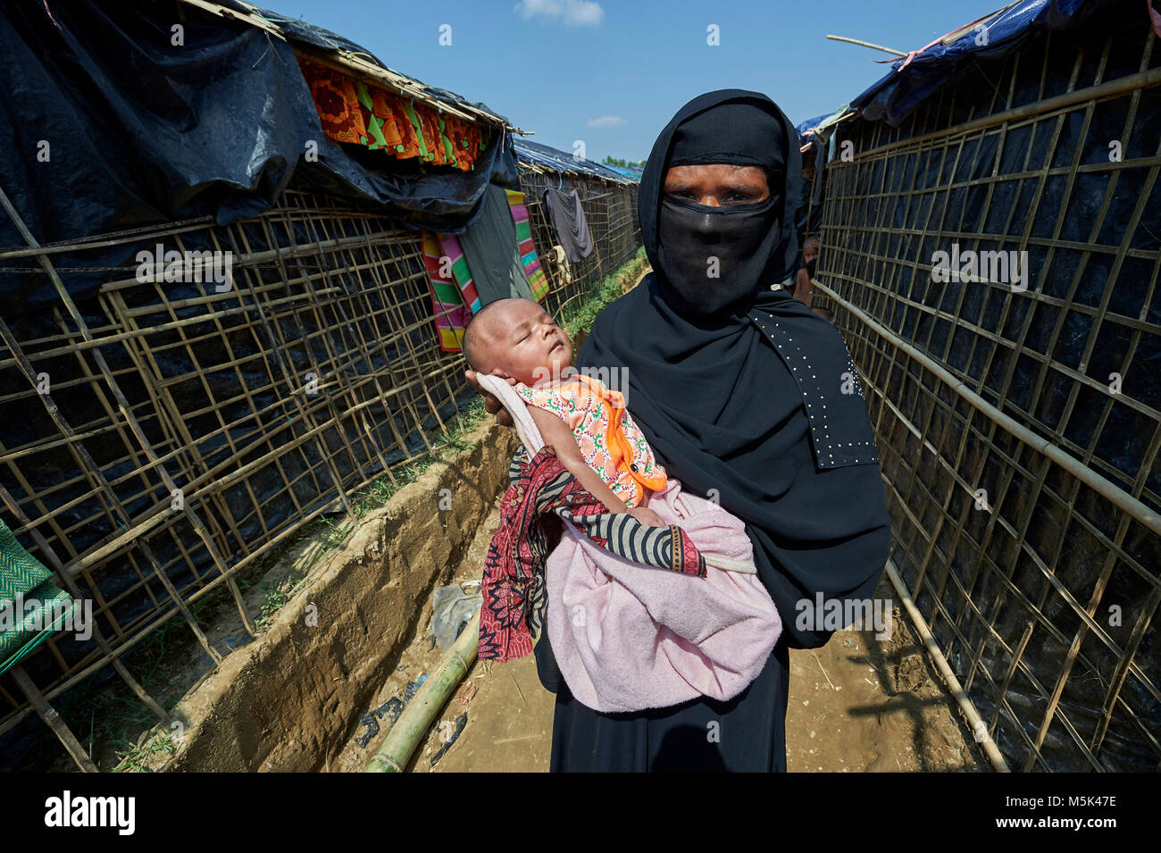 Hasina Belrasama holds her daughter Shuhia in the Jamtoli Refugee Camp near Cox's Bazar, Bangladesh. Stock Photo