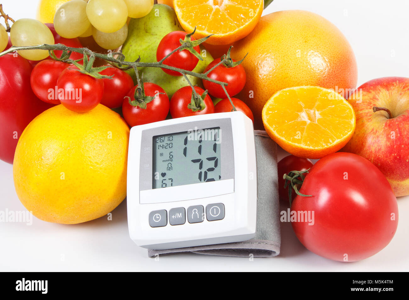 Blood pressure monitor with result of measurement and fruits with ...