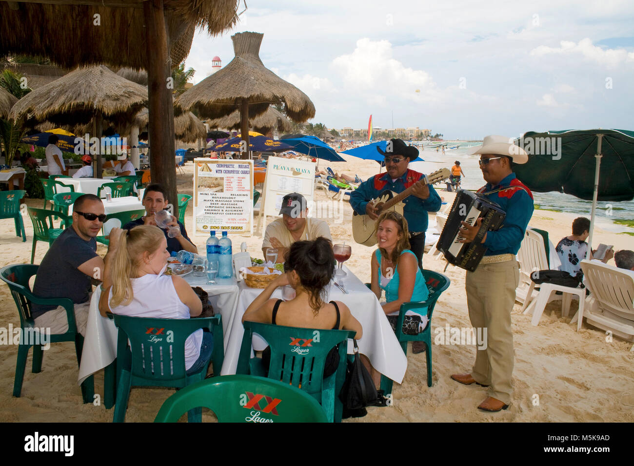 Mexican musicians playing a serenade at a table of a beach restaurant, beach of Playa del Carmen, Mexico, Caribbean Stock Photo