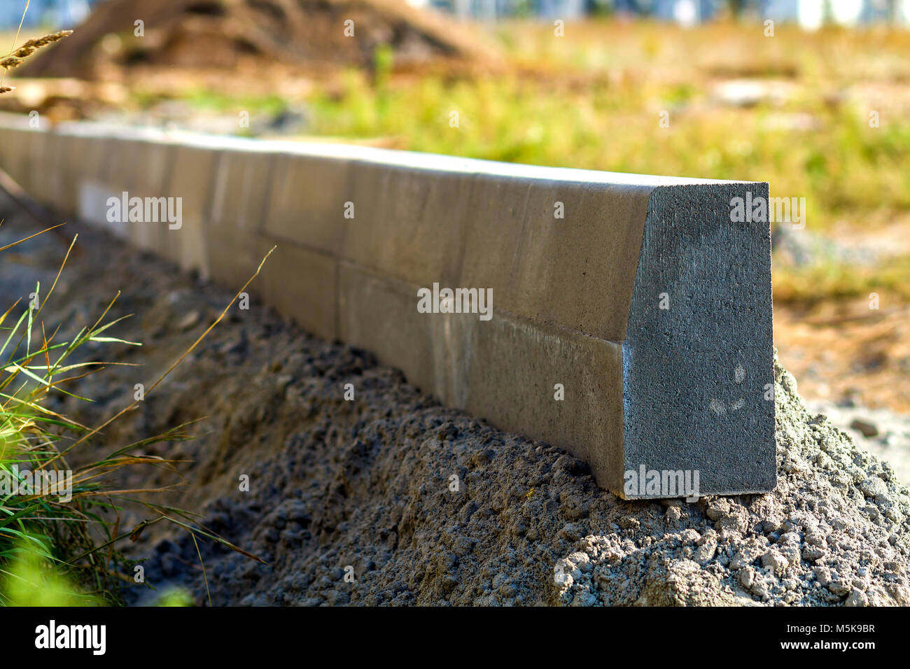 Concrete curb installation works at road construction site. Shallow DOF Stock Photo Alamy