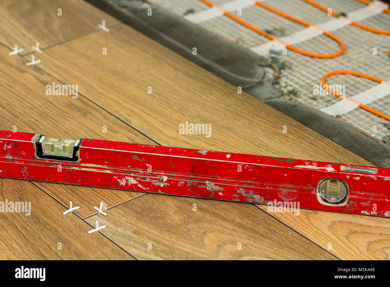 Installation of ceramic tiles and heating elements in warm tile floor