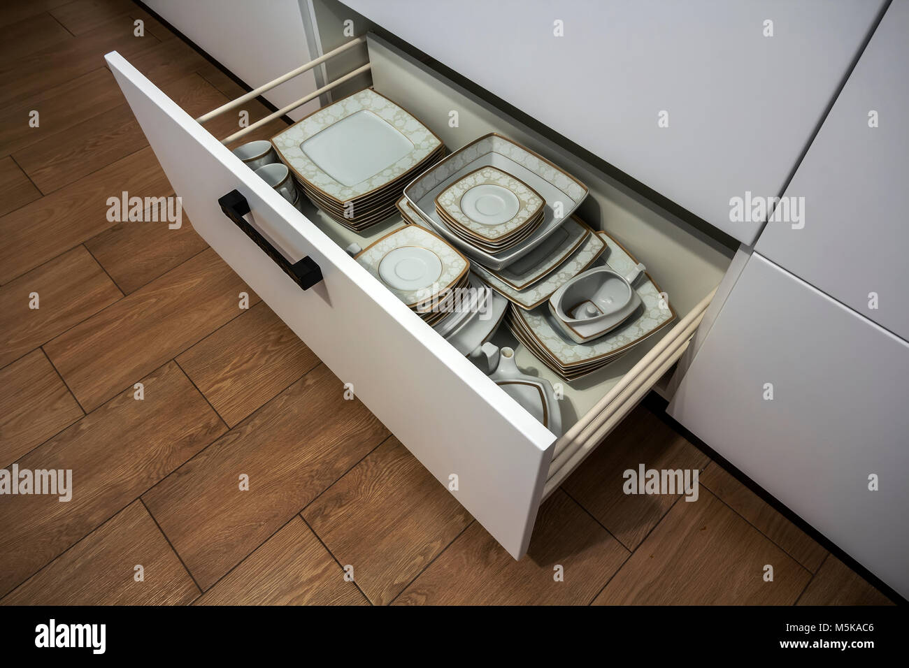 Open kitchen drawer with plates inside, a smart solution for kitchen