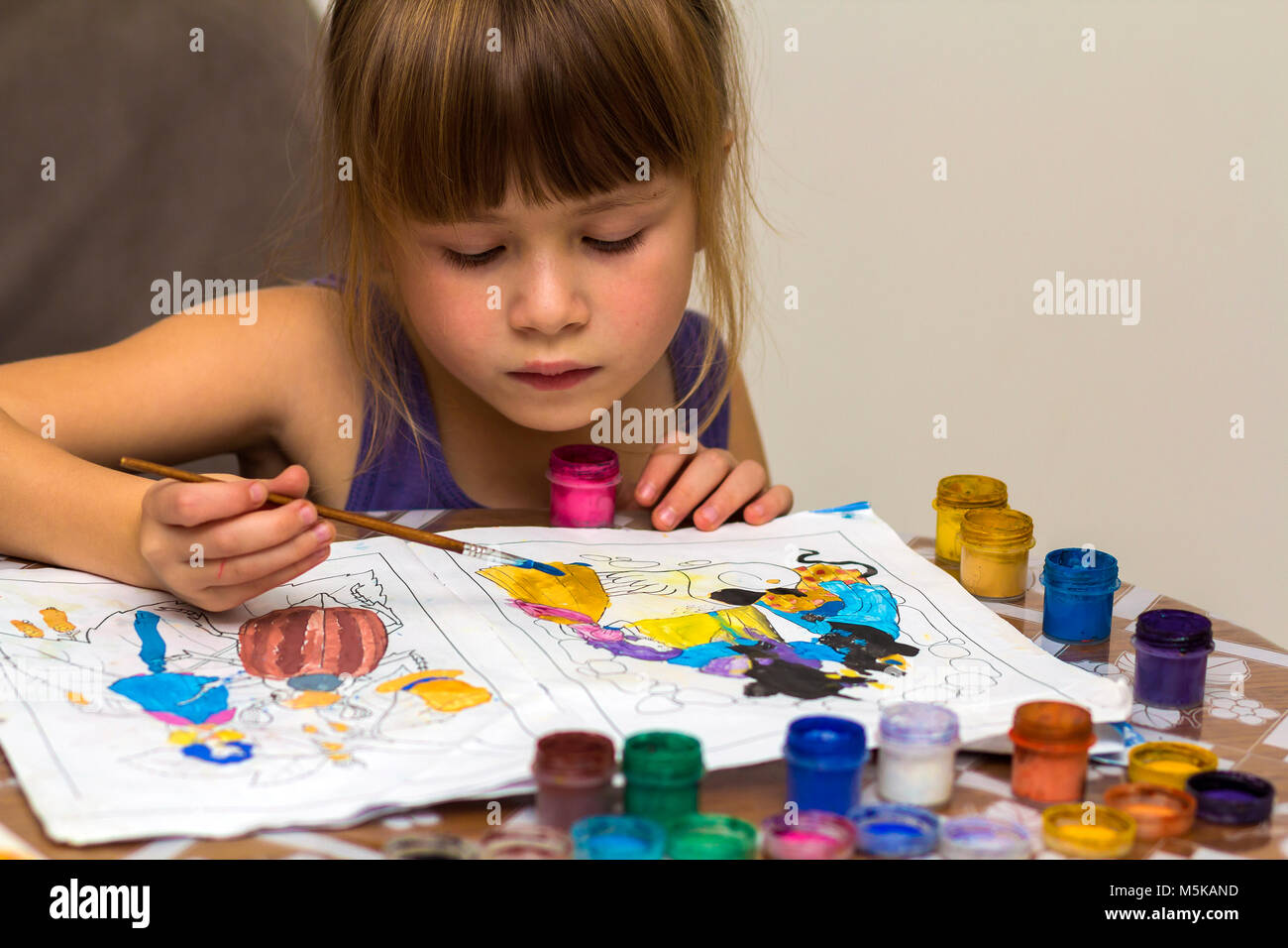 Cute little girl painting with brush and colourful paints Stock Photo ...