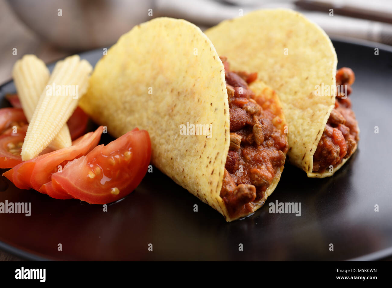 Tacos with chili con carne, tomato, and pickled baby corns Stock Photo