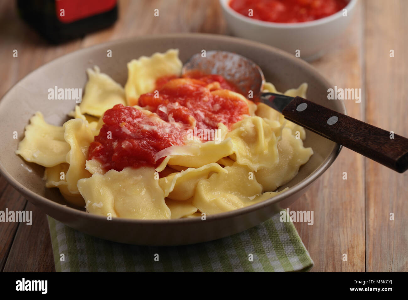 Italian ravioli with shredded Parmesan cheese and tomato sauce Stock Photo