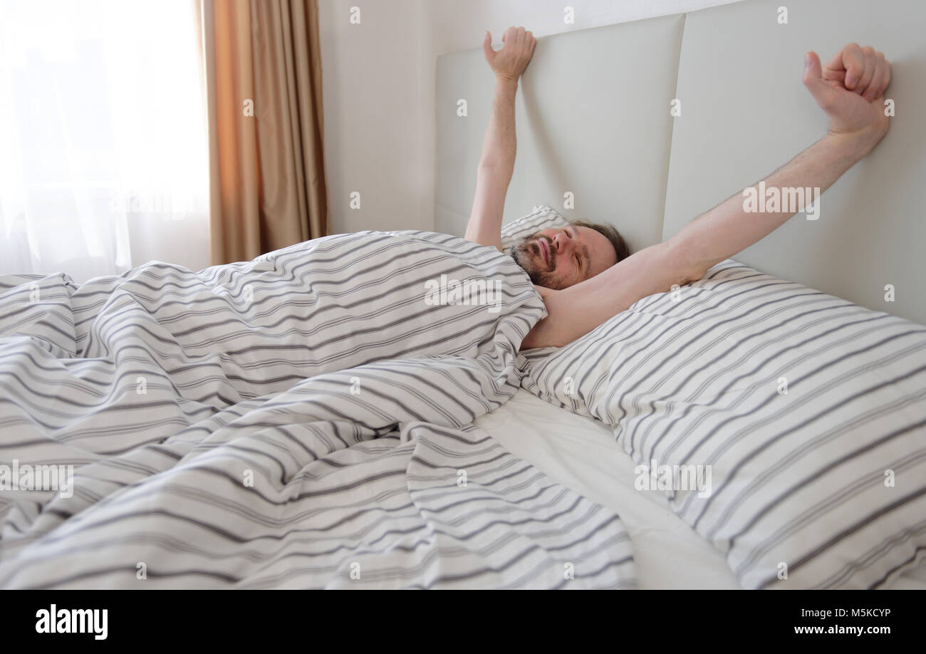 Mature man waking up in his bedroom Stock Photo