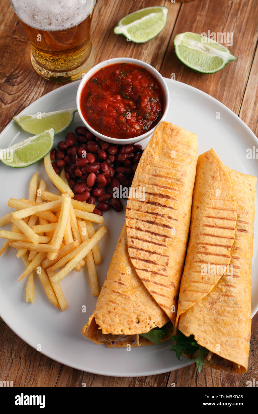 Chicken burritos with French fries, red bean, salsa sauce, and beer