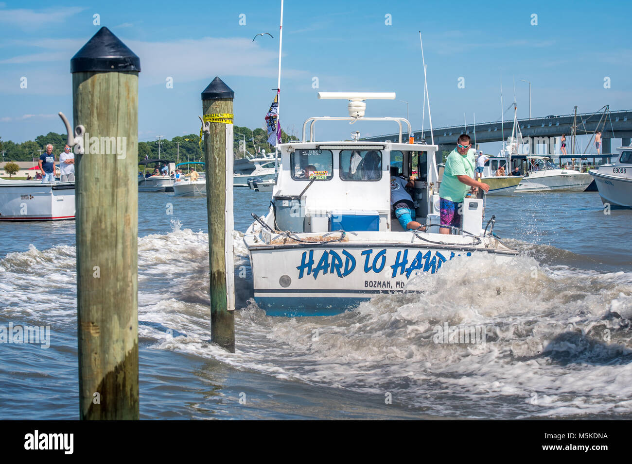 Motor boat kicks up water in its wake as it swings into dock, Deal