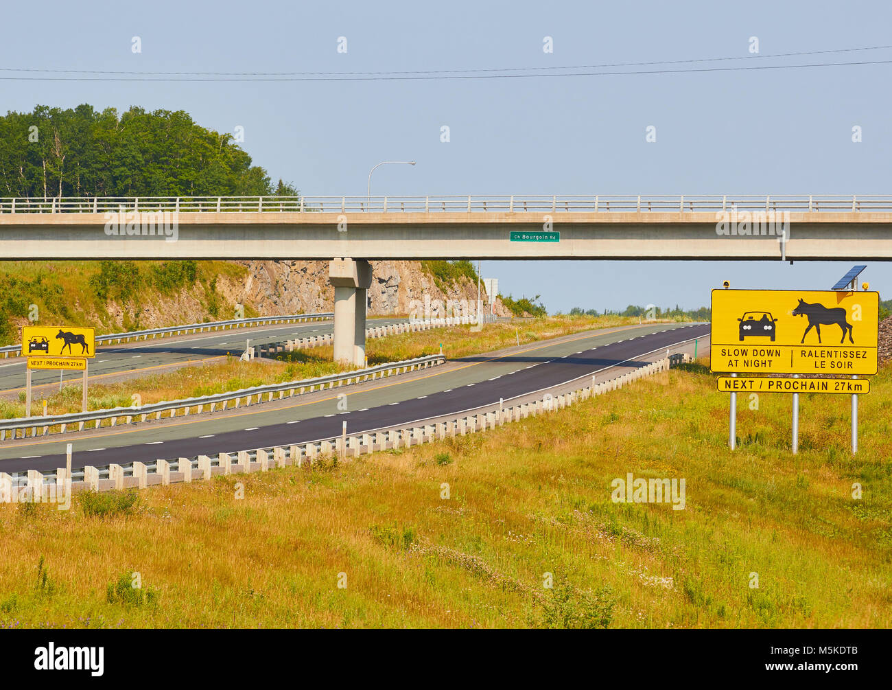 Sign in English and French warning drivers of possibility of moose on the road at night, Quebec Province, Canada Stock Photo