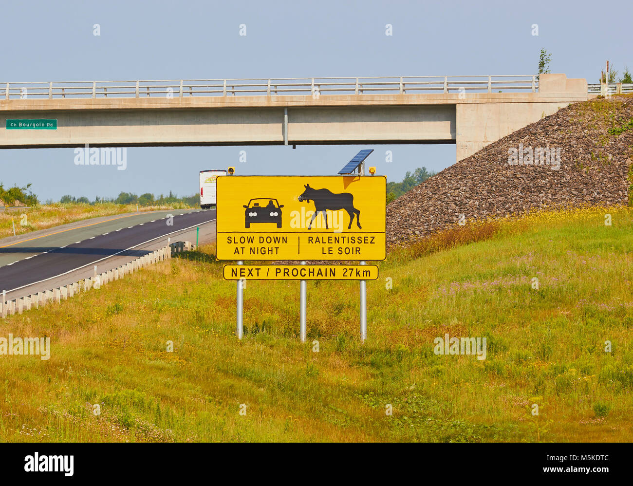 Sign in English and French warning drivers of possibility of moose on the road at night, Quebec Province, Canada Stock Photo