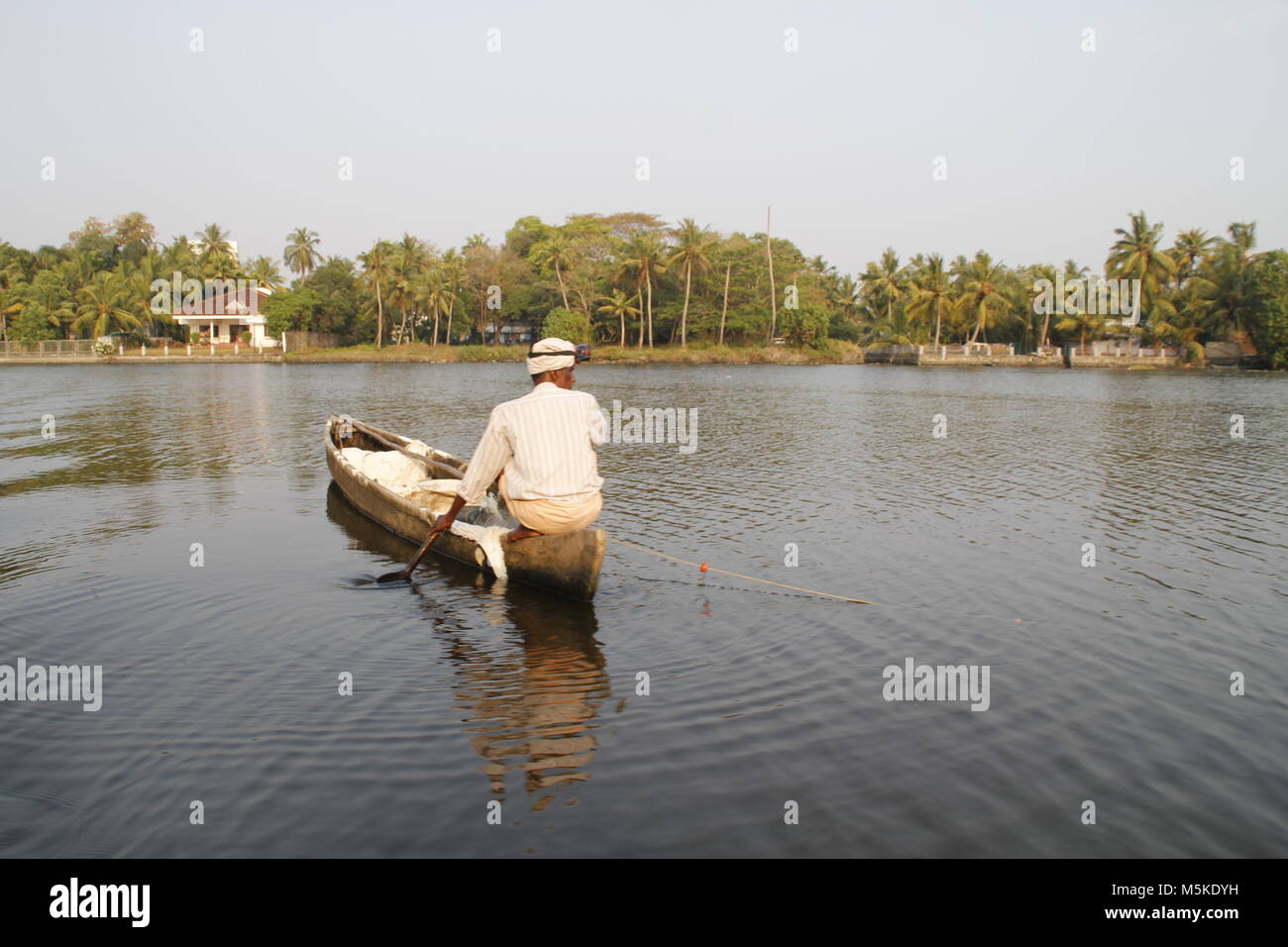 Local fisherman on his board in the backwaters of alapuzha, kerala, India Stock Photo