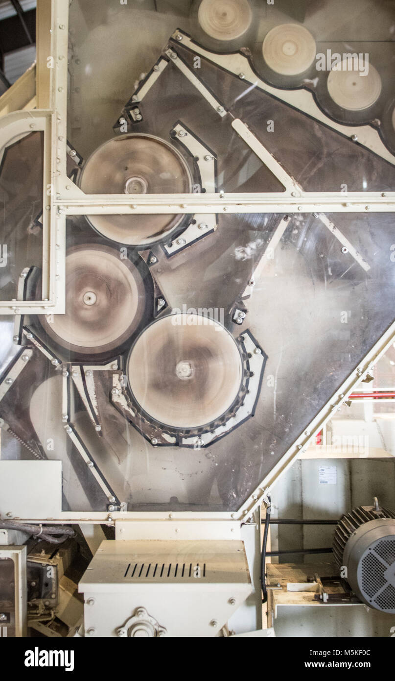 Exposed side of Micro Cotton Gin revealing mechanical rollers spinning