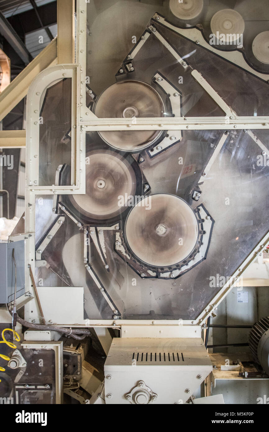 Exposed side of Micro Cotton Gin revealing mechanical rollers spinning