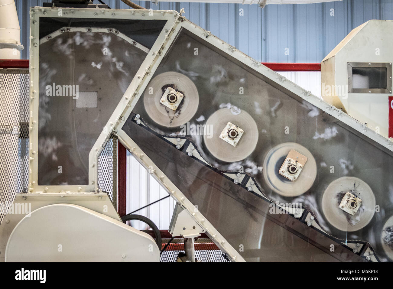Exposed side of Micro Cotton Gin revealing mechanical rollers spinning