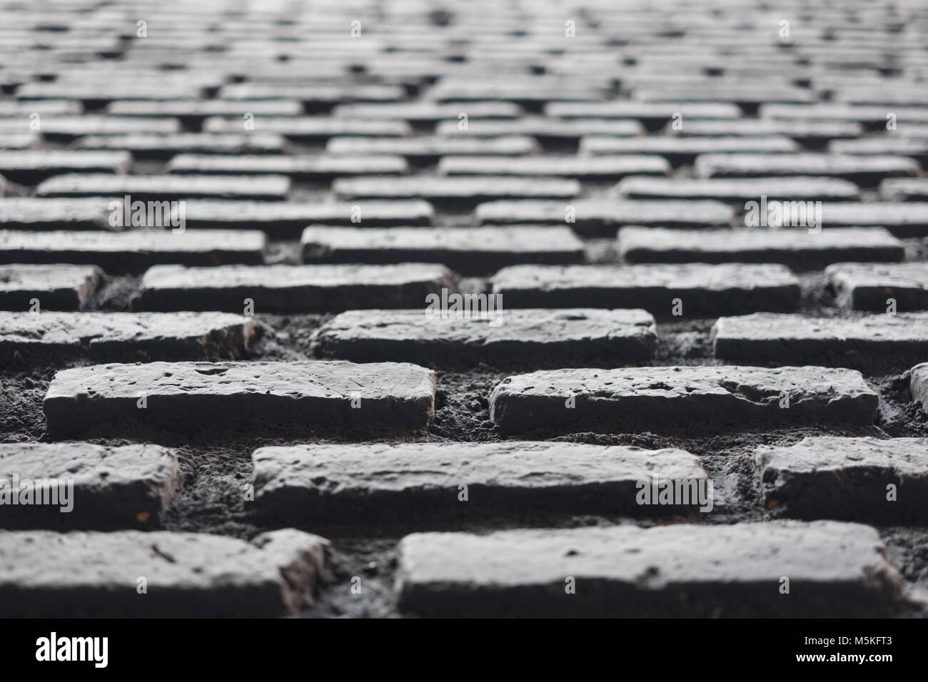Brick in black colour work wall pattern in one point perspective view, craftmanship in construction building, selective focus. Stock Photo