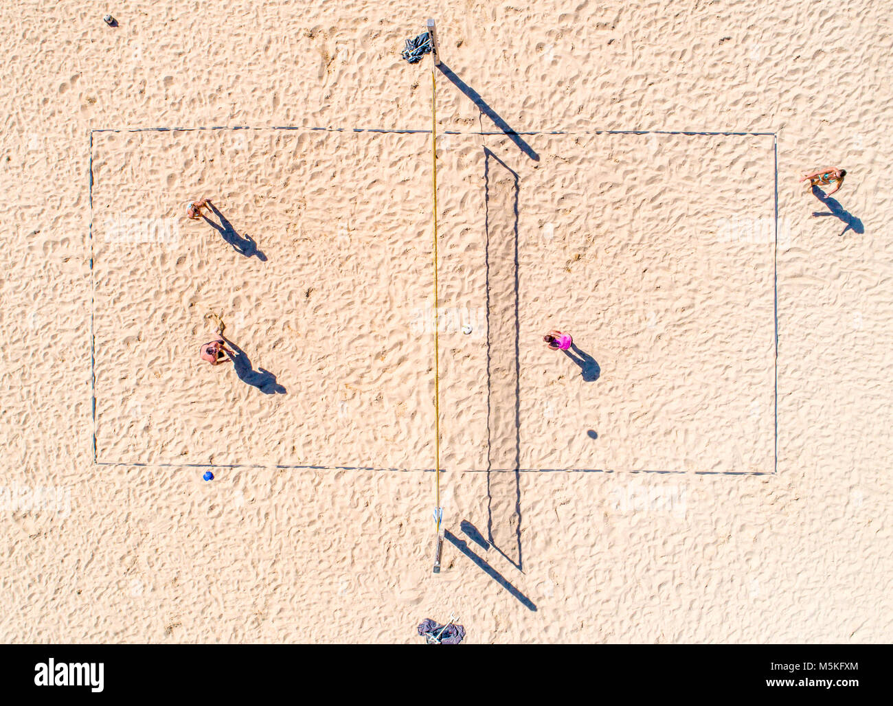 Shot from directly above of a group of people playing beach volleyball