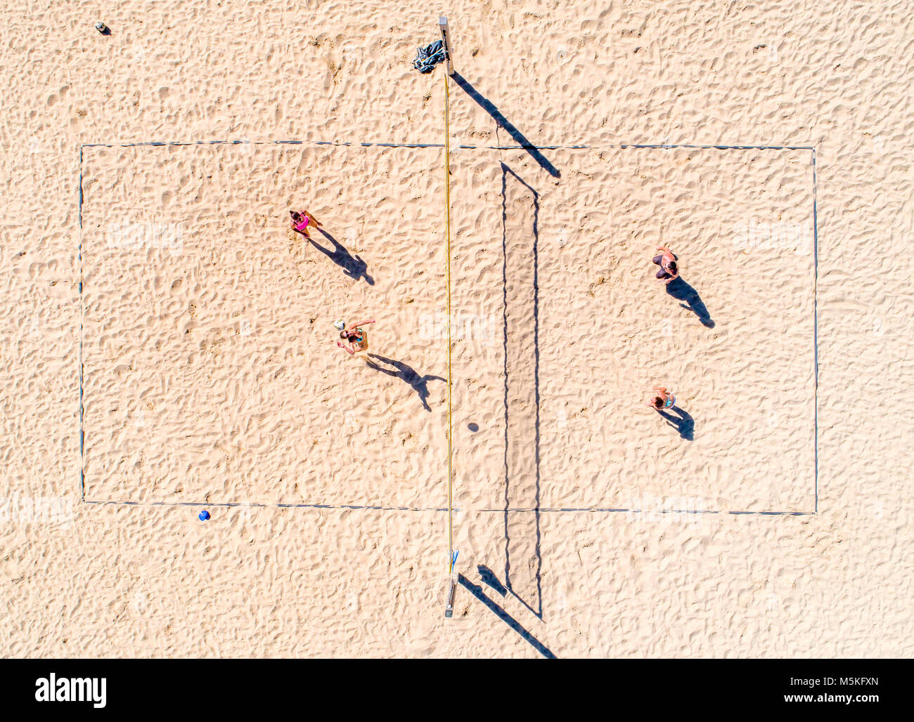 Shot from directly above of a group of people playing beach volleyball