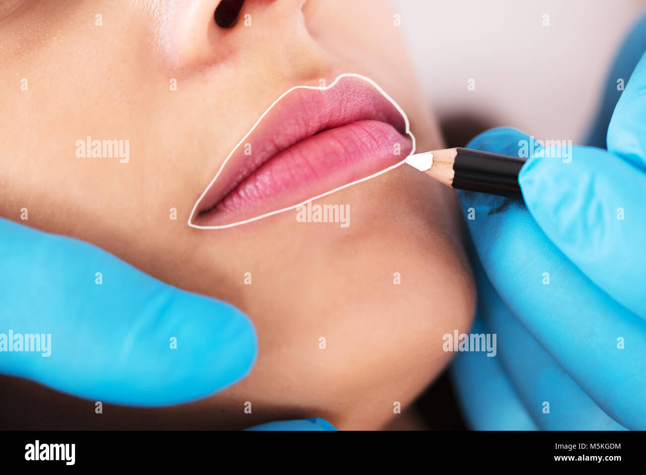 Cosmetologist Applying Permanent Make Up On Young Woman's Lips Stock Photo