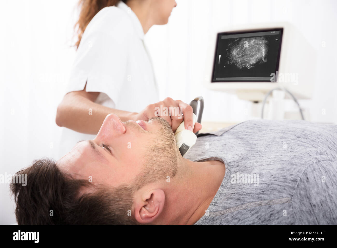 Man Undergoing The Medical Ultrasound Examination In Clinic Stock Photo
