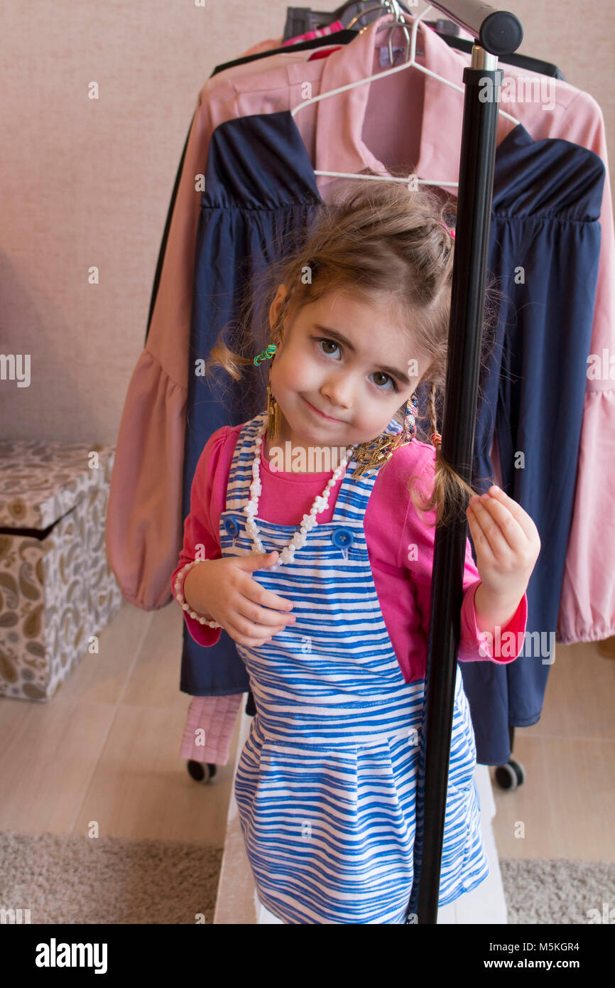 Clouse-up portrait of cheerful little girl choosing clothes Stock Photo