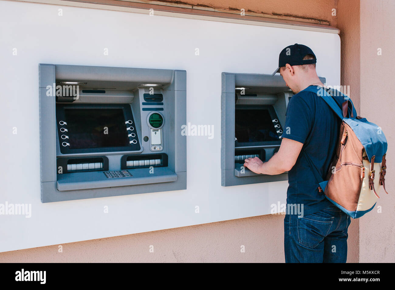 The tourist withdraws money from the ATM for further travel. Finance, credit card, withdrawal of money. Journey. Vacation. Stock Photo