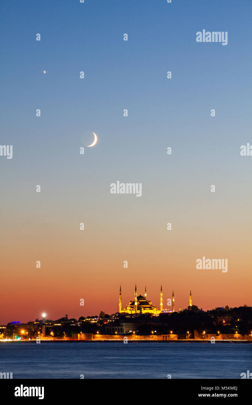 Blue Mosque and Hagia Sophia at twilight with crescent moon in the sky, Istanbul, Turkey. Stock Photo