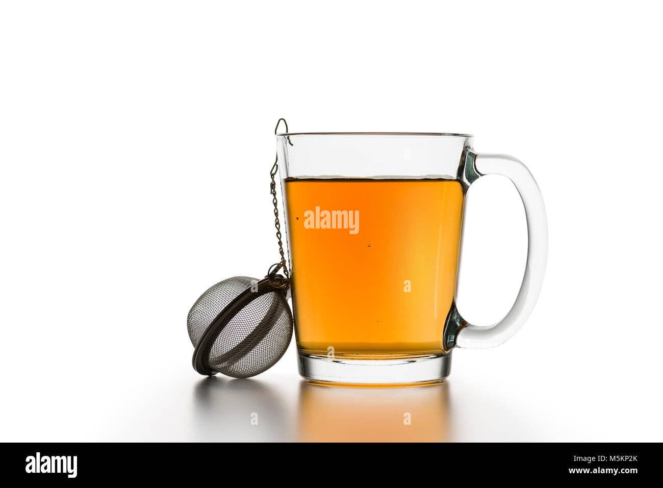 glass cup of tea with empty tea infuser on white table Stock Photo Alamy