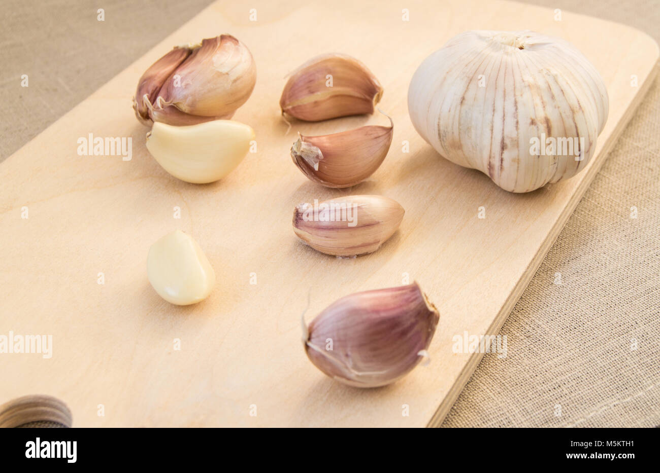 Cloves and clove of garlic on wooden cutting Board Stock Photo - Alamy