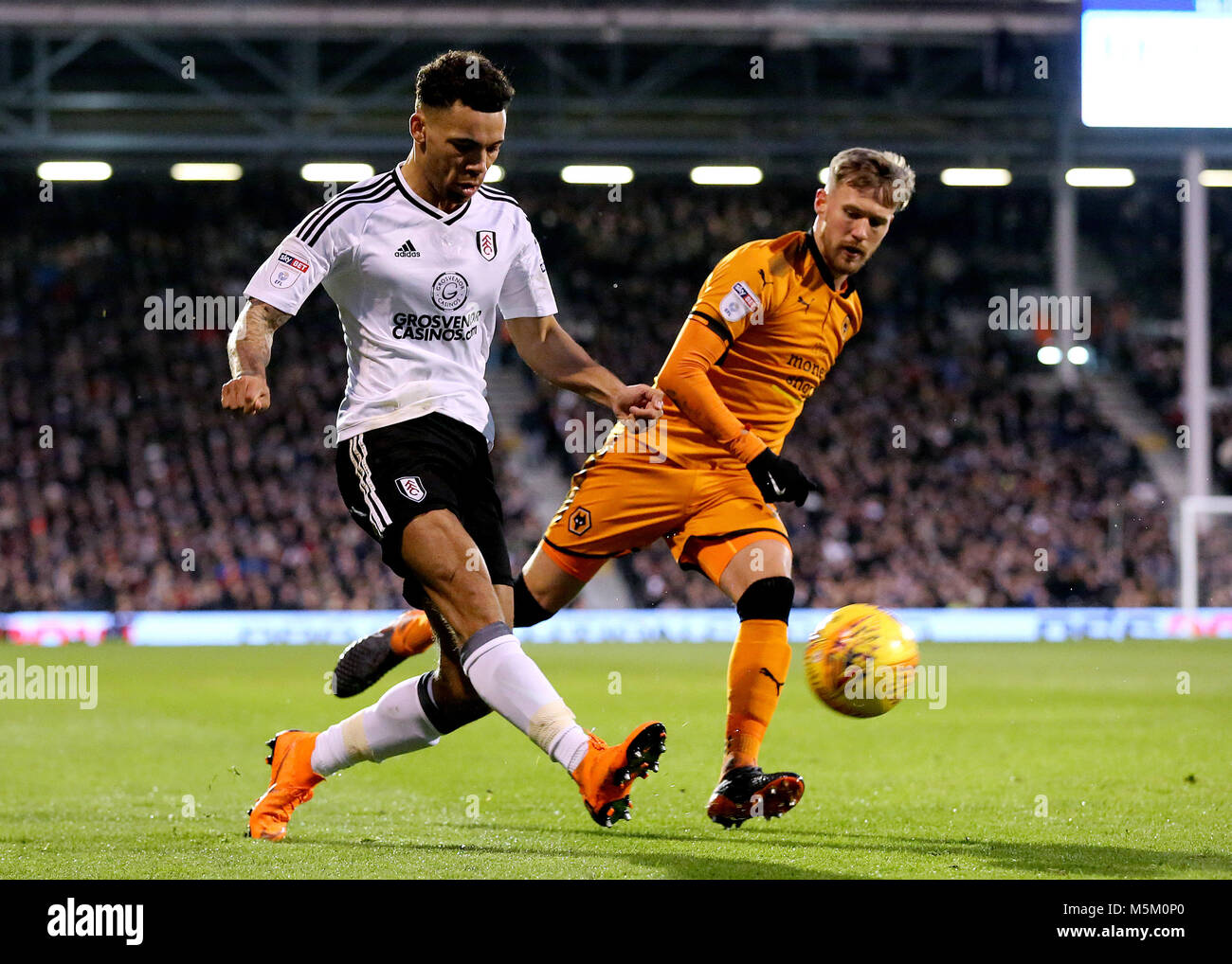 Fulham's Ryan Fredericks beats Wolves Barry Douglas and crosses into the Wolves area during the Championship match at Craven Cottage, London. Stock Photo
