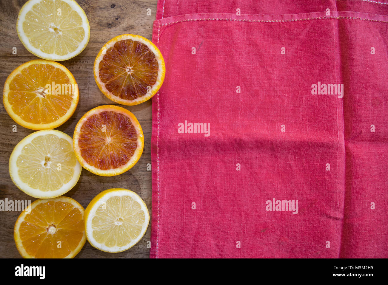 oranges and lemons cut half and neal a red napkin Stock Photo