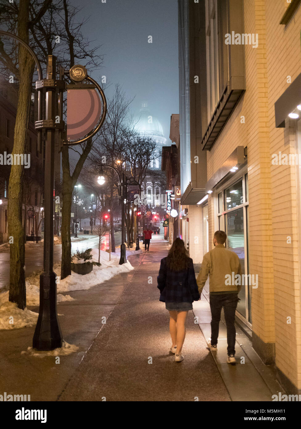 Young couple strolling along State Street on Valentines night. Madison, Wisconsin. Stock Photo