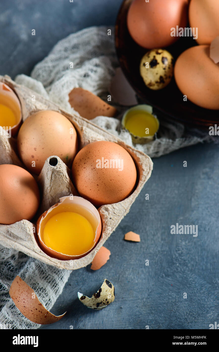 Yolk in an eggshell close-up. Brown hen eggs in a carton tray with copy space. Cooking with fresh ingredients concept. Stock Photo