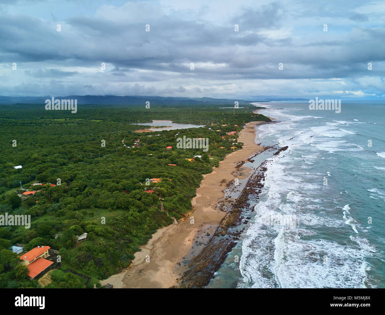 Ocean shore beach with rocks aerial view in cloudy day Stock Photo