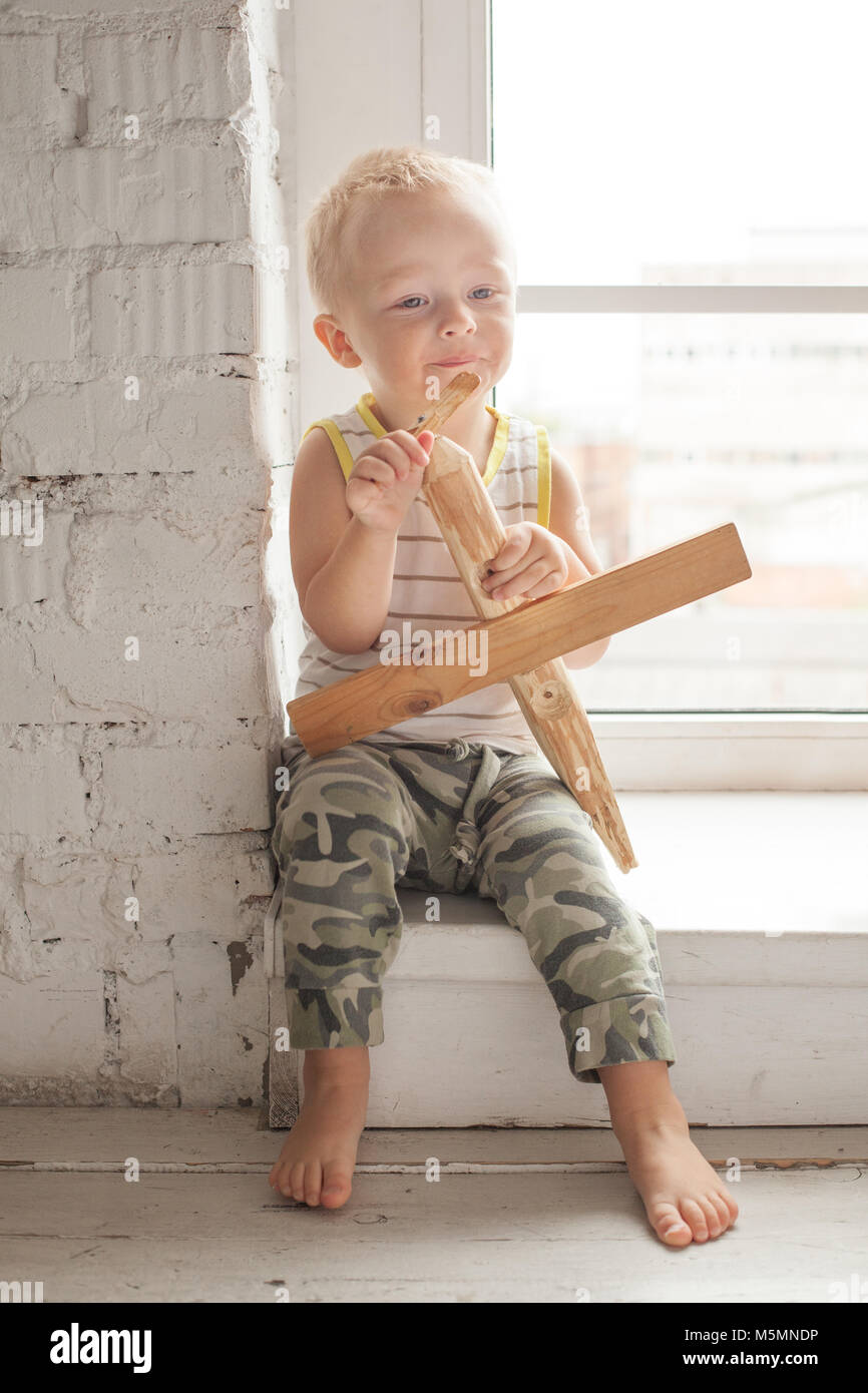 Cute Child Boy with Wooden Plane Toy at Home Stock Photo - Alamy