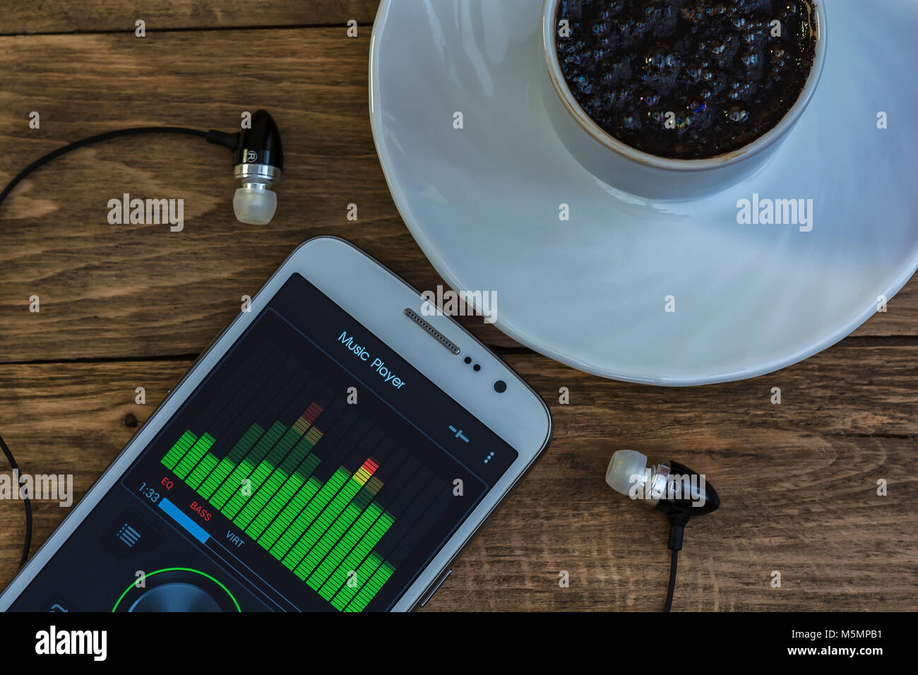 Close-up of a smartphone with the EQ on the display and coffee Cup on a saucer Stock Photo